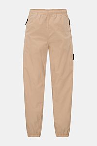 Stone Island Jogpants sand, frontale Ansicht, luftig-leichte Baumwolle, elastischer Bund mit Tunnelzug, Zipper-Taschen, Tapered Fit, knöchellang.
