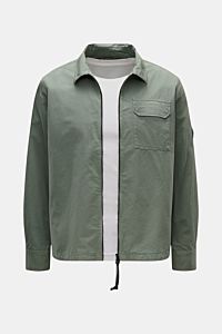 Front view of C.P. Company Overshirt salbei in slim fit, pure cotton, lightweight with two-way zipper, chest pocket, sleeve logo pocket, and cuffed sleeves. Lässiges Layering-Piece: Das Overshirt von C.P. COMPANY ist der ideale Begleiter für urbane Frühli