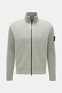 Front view of Stone Island Strickjacke 'Rib' salbei in sage green, ribbed knit cotton cardigan with soft feel, regular fit, stand-up collar, two-way zipper, comfortable cuffs, and compass badge on the upper arm. Zeitloses Layering-Piece: Die Strickjacke v