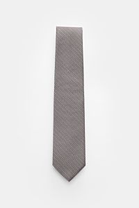 Tom Ford Seidenkrawatte rosé/schwarz gemustert im Hahnentrittmuster, reine Seide, dezenter Glanz, Logo-Stitching, flach liegend von oben fotografiert.