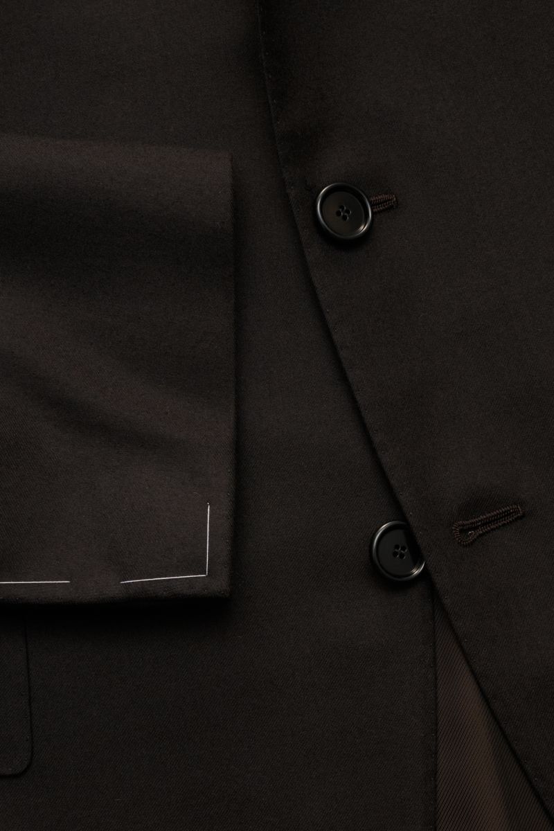 Close-up view of the dark navy Cesare Attolini Anzug showing the finely woven Super 150'S wool fabric, tailored three-button jacket with unfinished sleeve cuffs, and smooth lining, highlighting Neapolitan craftsmanship in perfection.