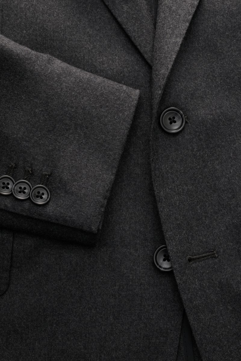 Nahaufnahme des dunkelgrau melierten Tagliatore Anzugs 'Vesuvio' mit tailliertem Sakko, fallendem Revers und Knöpfen, Seitenansicht.