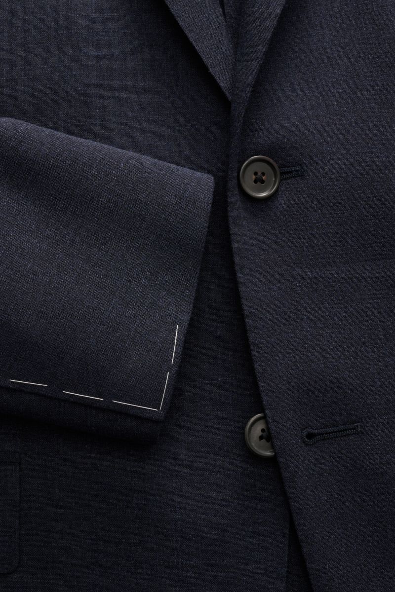 Nahaufnahme des navy melierten Corneliani Anzugs aus Schurwolle, Seide, Leinen, Slim Fit, tailliertes Sakko mit fallendem Revers, unfertigen Ärmelabschlüssen.
