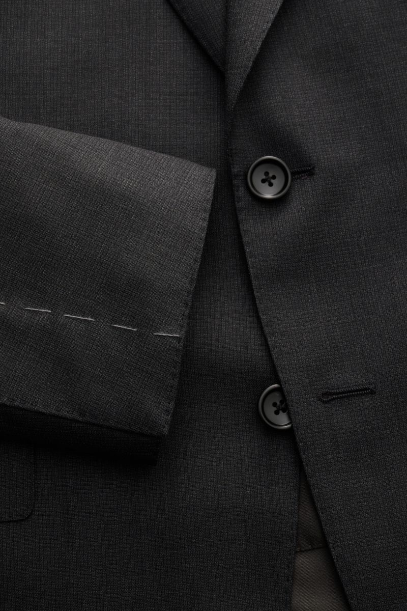 Close-up front view of the Tom Ford Anzug 'Shelton' anthrazit meliert jacket sleeve and buttons, showing the slim fit, fine wool with a smooth, textured weave, two-button tailored style with notch lapel. Perfektes Auftreten mit TOM FORD: Mit dem Anzug 'Sh