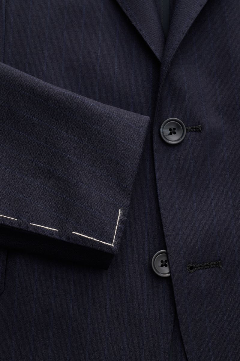 Close-up front view of the Tagliatore Anzug 'Vesuvio' navy gestreift suit jacket, showcasing slim fit elastic wool fabric with soft touch and classic pin-stripes, featuring a tailored two-button style, falling lapel with pin, and detailed stitching on the