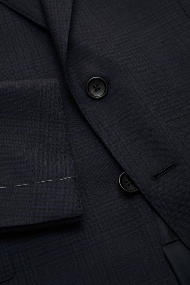 Nahaufnahme des navy/schwarz karierten Tom Ford Anzugs 'Shelton' mit Slim Fit, Patten-Taschen und feiner Wollstruktur aus schräger Perspektive.