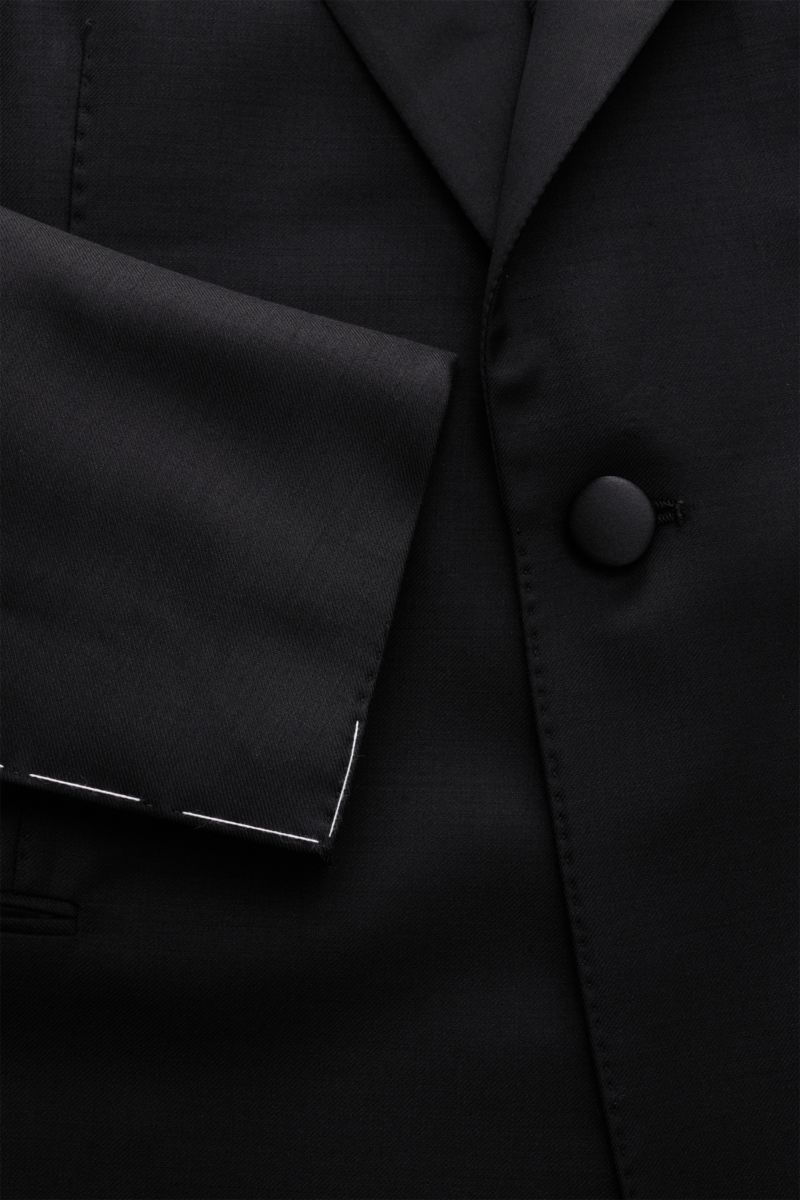 Nahaufnahme des Stile Latino Smoking schwarz aus reiner Wolle, Slim Fit, mit tailliertem Ein-Knopf-Sakko und feiner Köperstruktur.
