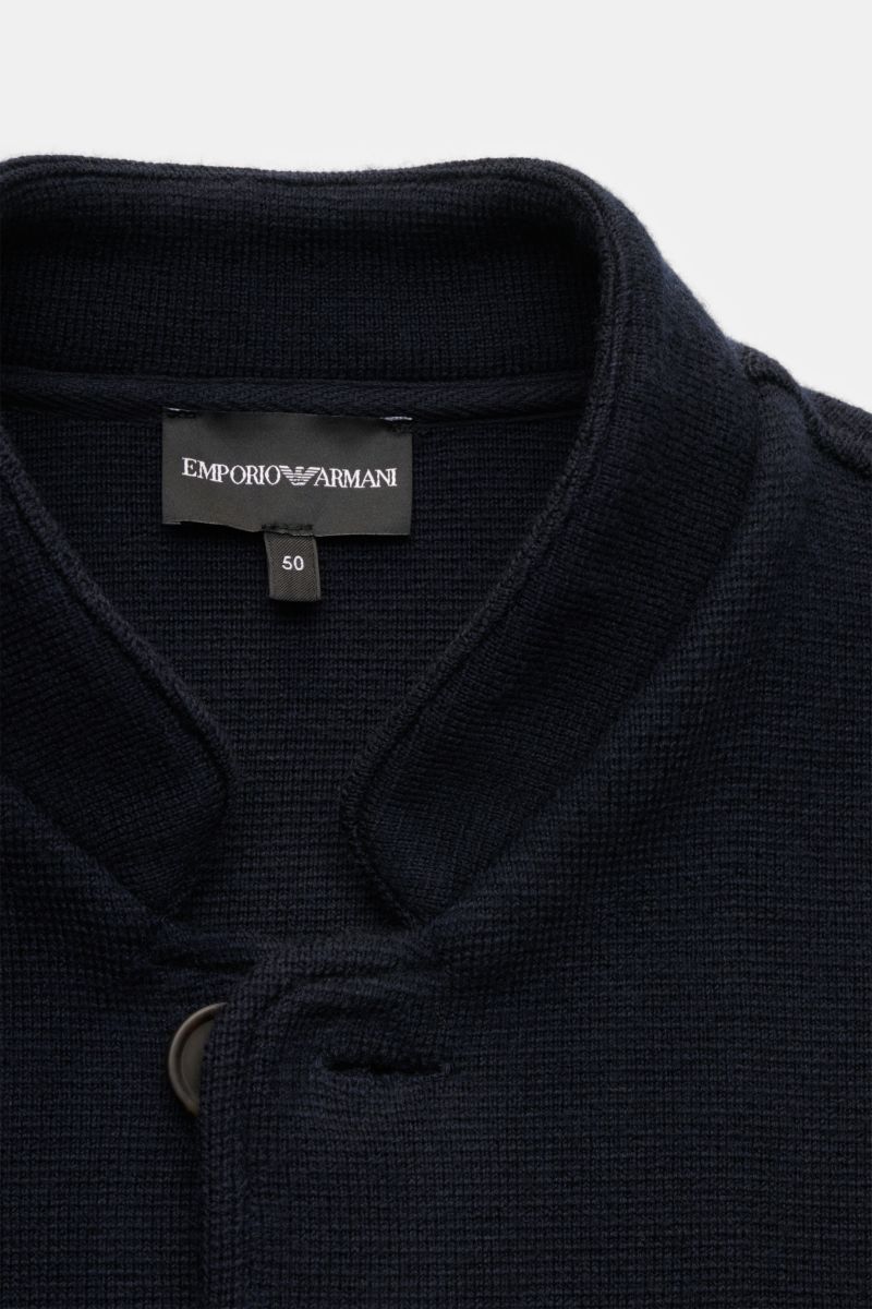 Close-up front view of the collar and label of the Emporio Armani Strickblazer 'Travel Essential' navy, knitted from pure virgin wool. Der Komfort einer Strickjacke mit der Eleganz eines Sakkos: EMPORIO ARMANI gelingt der Spagat zwischen beiden Welten 