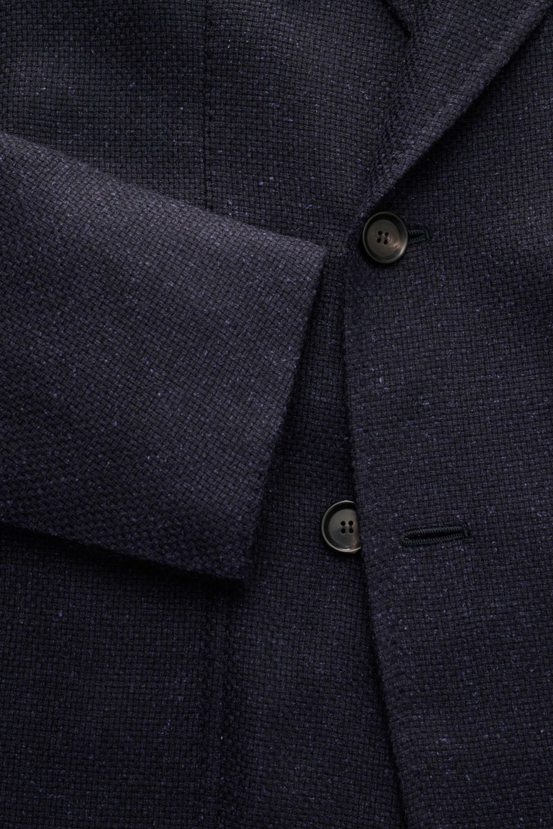 Close-up front view of the Stile Latino Smart-casual jacket 'Andrea' dark navy, showing textured fabric, two buttons, and sleeve cuff detail.

An eye for detail and an impeccable finish is what we have come to expect from the Neapolitan artisans, and t