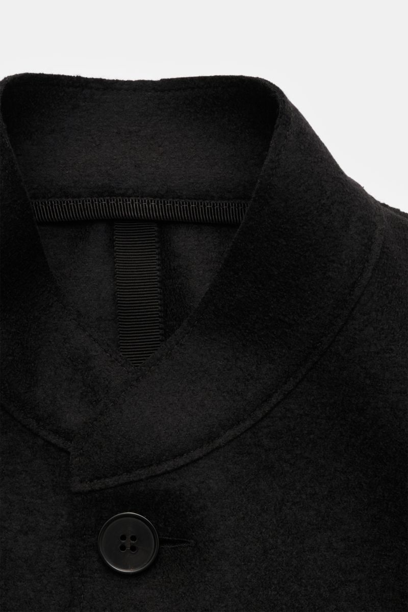 Nahaufnahme des schwarzen Harris Wharf London Sakkos mit Stehkragen, Vier-Knopf-Stil und offener Kantenverarbeitung aus reiner, gefilzter Schurwolle.