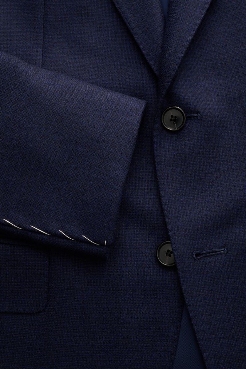 Nahaufnahme des Caruso Sakko 'Aida' navy von vorne, zeigt reine Wolle, Slim Fit, Zwei-Knopf-Stil, fallendes Revers, Brust- und Hüfttaschen, unfertige Ärmelabschlüsse.