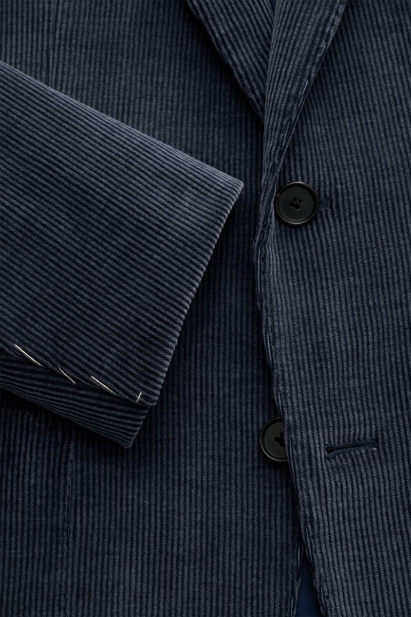 Nahaufnahme des Caruso Cordsakko 'Aida' graublau aus Baumwoll-Woll-Cord, Slim Fit, leichter Stretch, Zwei-Knopf-Stil, fallendes Revers, klassische Brusttasche, aufgesetzte Hüfttaschen, unfertige Ärmelabschlüsse, rückwärtige Seitenschlitze, tonaler Futters