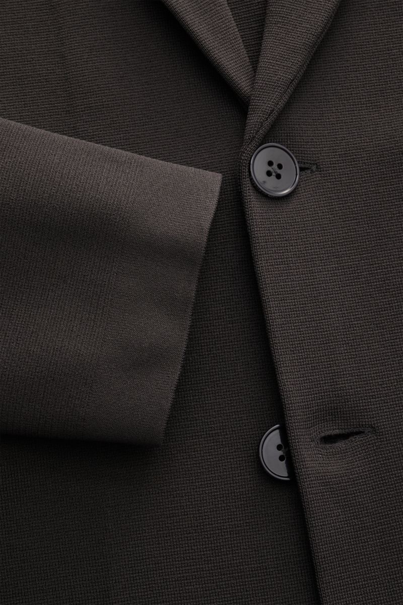 Nahaufnahme des Emporio Armani Strickblazer 'Icon' anthrazit aus nachhaltiger Viskose, Jersey mit Slim Fit, Zwei-Knopf-Stil, fallendem Revers, aufgesetzten Hüfttaschen und Unconstructed Design, fotografiert von schräger Frontperspektive.