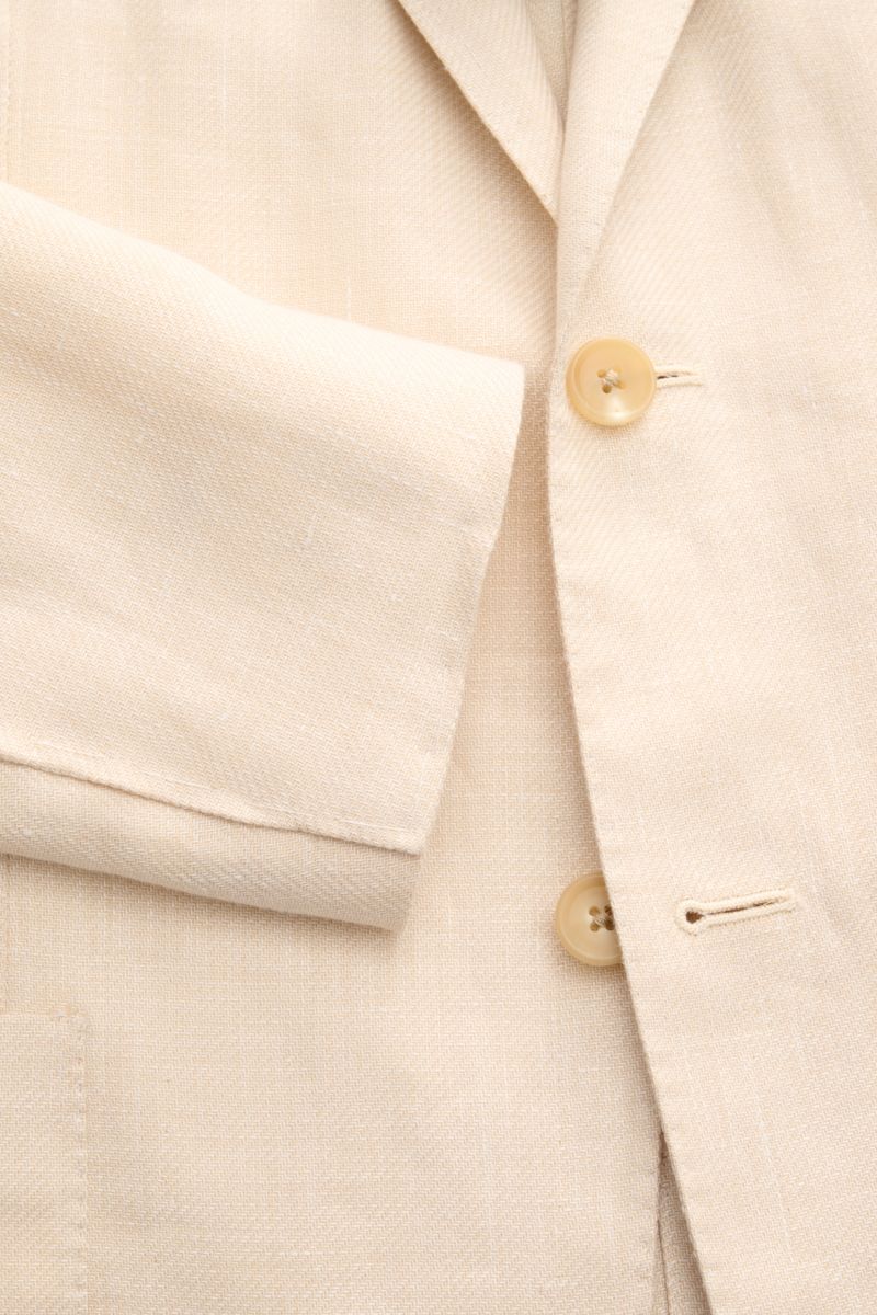 Close-up front view of Corneliani Sakko creme showing soft textured fabric, two cream buttons, and tailored sleeve. Formvollendeter Stil von CORNELIANI: mit optimalem Fit aus italienischer Meisterhand wurde dieses Sakko aus leichtem Lyocell und Leinen gef