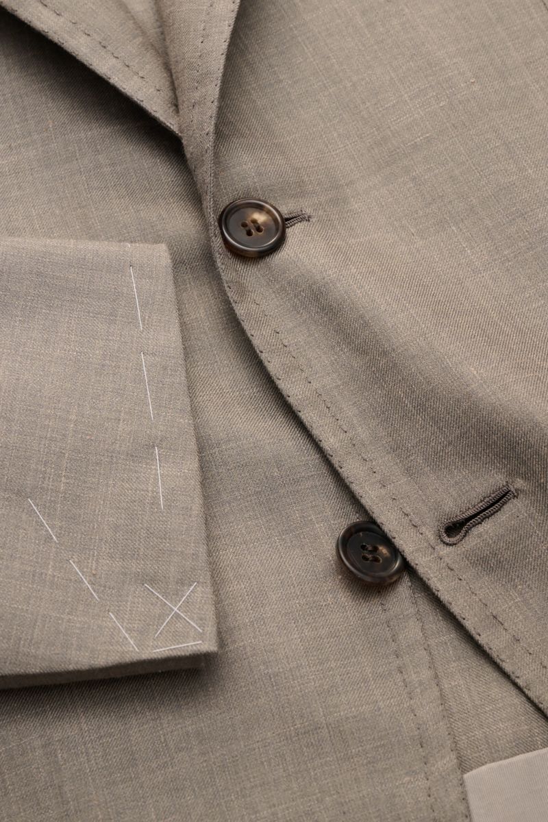 Close-up front view of the Brioni Smart-casual jacket 'Amalfi' grey mottled, showcasing its silk-cashmere-linen blend, soft feel, slim fit, three-button style, step lapel, classic breast pocket, patch hip pockets, unfinished sleeve cuffs, side vents, half