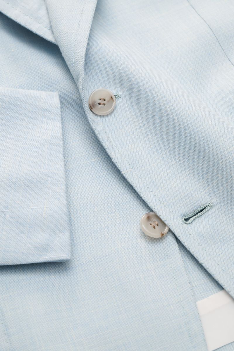Close-up top-down view of the pastel blue mottled fabric and buttons on the Brioni Smart-casual jacket 'Amalfi', highlighting its wool-silk-linen blend. A confident choice for stylish looks: The exquisite wool-silk blend, refined with linen to create the 