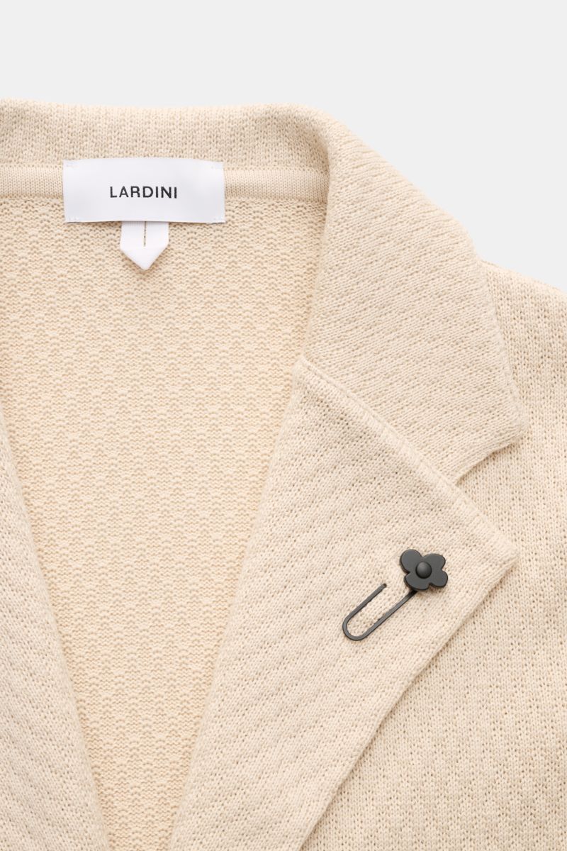 Lardini Strickblazer beige in Slim Fit, aus reiner Baumwolle mit markantem Strickmuster, fallendem Revers und Blütenpin, Nahaufnahme von vorne.