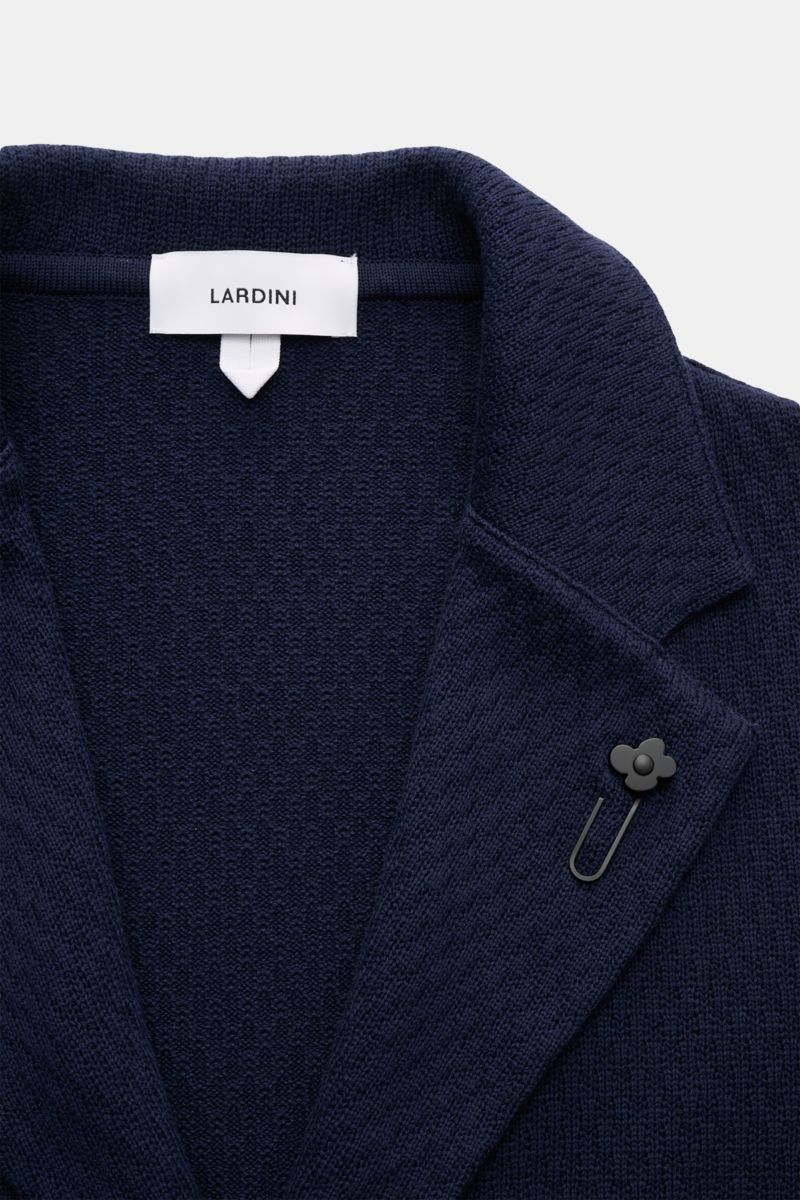 Nahaufnahme des Lardini Strickblazers navy von oben, zeigt fallendes Revers mit Blütenpin und markantes Baumwoll-Strickmuster.