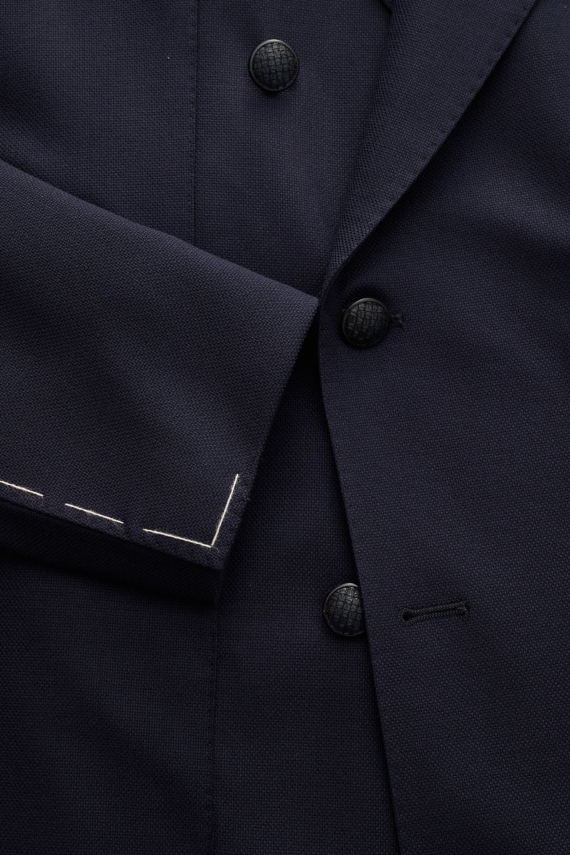 Nahaufnahme des Tagliatore Sakkos 'Monte Carlo' navy in Slim Fit aus elastischer Super 110'S Schurwolle, zweireihig mit drei schwarzen Knöpfen und Unconstructed Design, Blick auf Ärmel mit weißen Nähten.