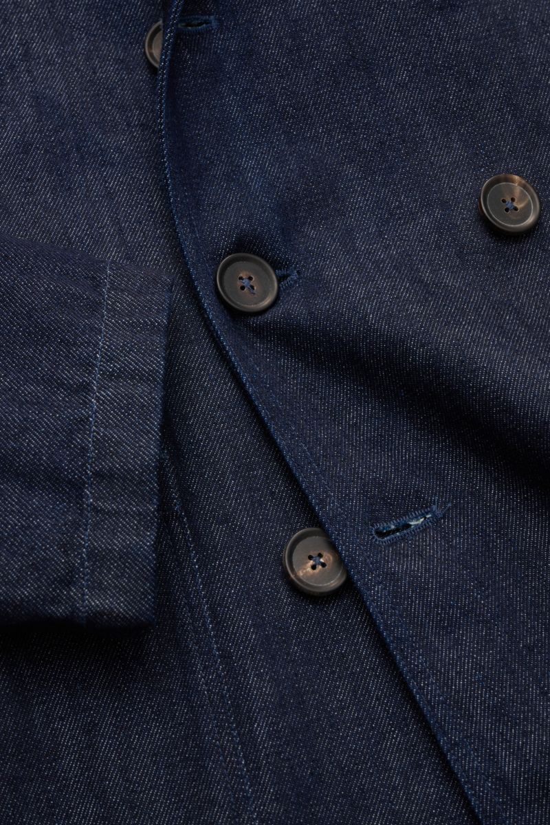Close-up front view of the Doppiaa Denim jacket 'Aansonia' navy, showing its pure cotton denim fabric, slim fit, double-breasted three-button style, step lapel, patch hip pockets, and unconstructed design, a new casual interpretation of a classic for urba