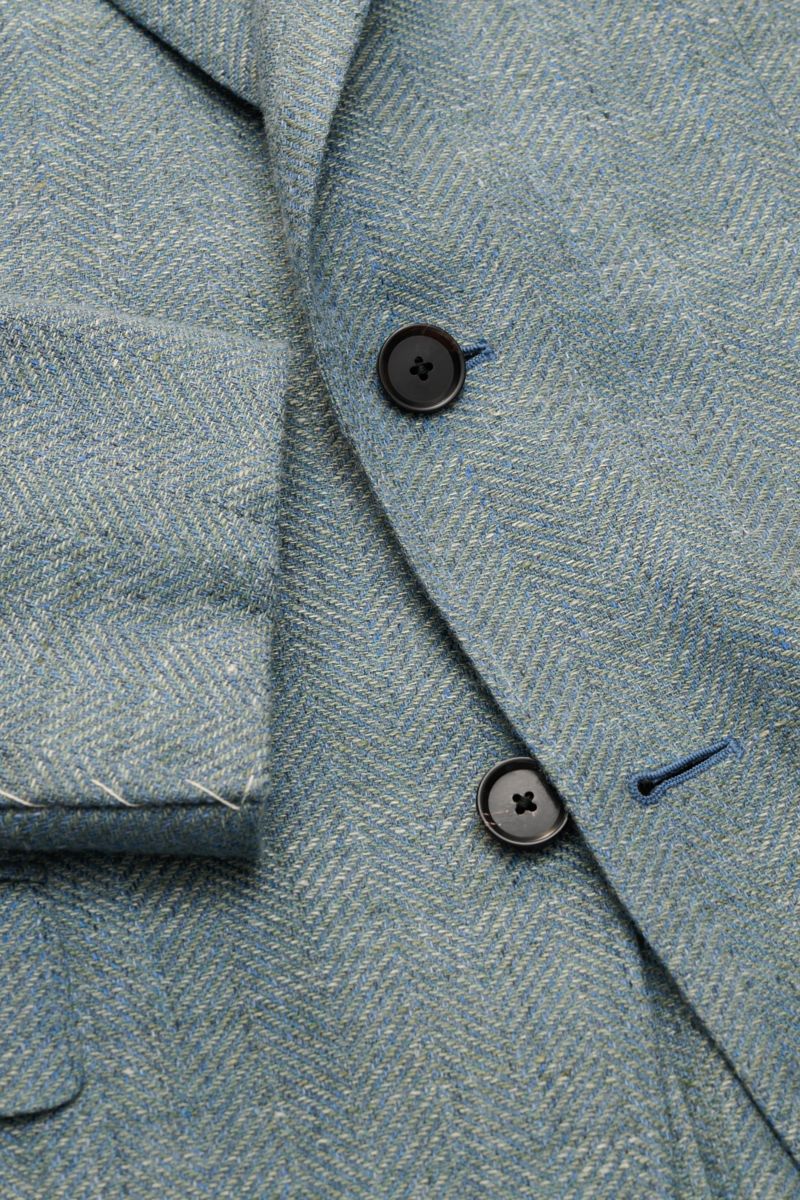 Close-up front view of Caruso Smart-casual jacket 'Aida' grey-green mottled showing herringbone texture, buttons, and unfinished cuffs.

In the smart-casual jacket 'Aida', CARUSO combines smart style with fabric in the natural materials linen and wool 