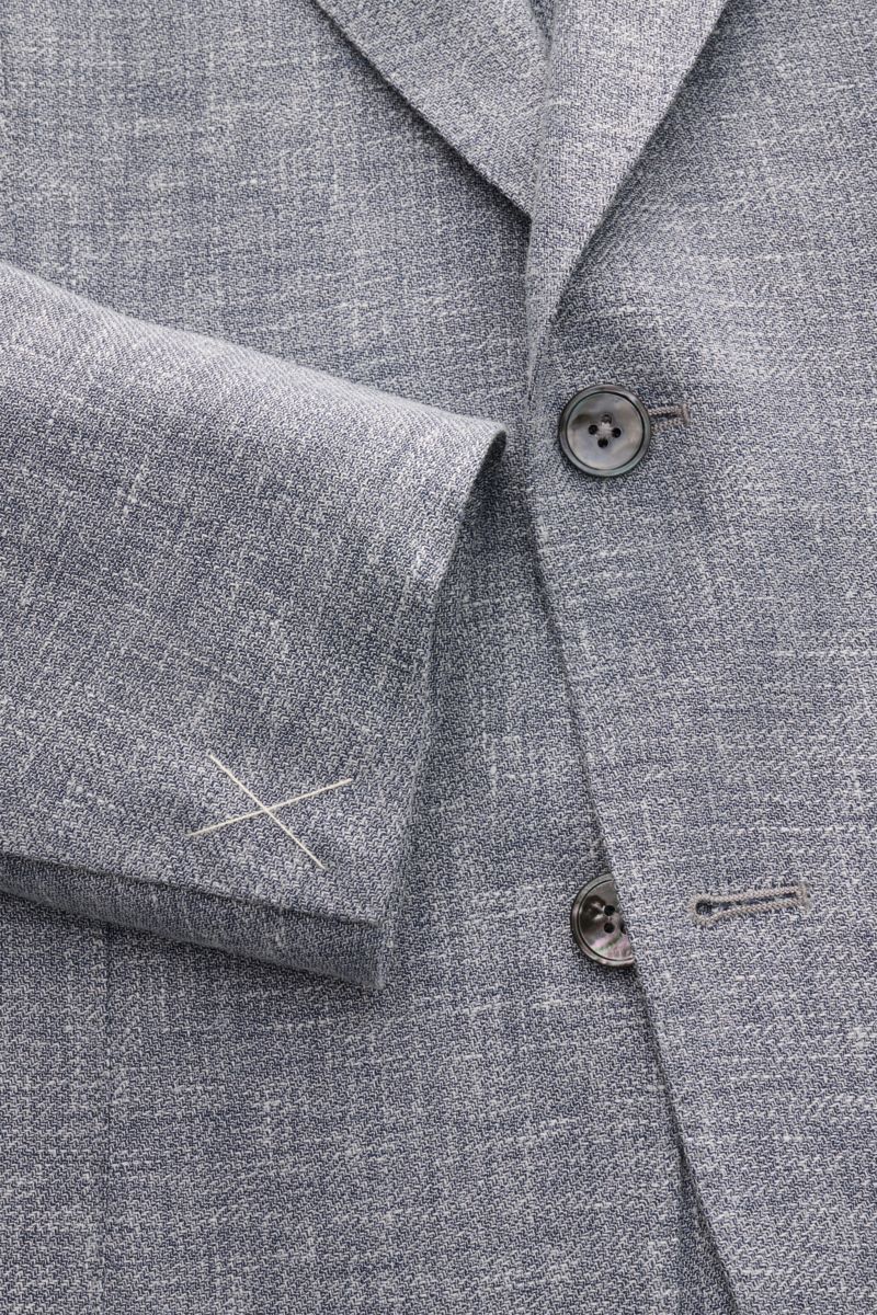 Nahaufnahme des Zegna Sakkos 'Riviera' dark navy/weiß meliert aus Leinen, Wolle, Seide, Slim Fit, tailliert, fallendes Revers, Zwei-Knopf-Stil, mit feiner Webstruktur und weichem Griff, fotografiert von vorne oben.