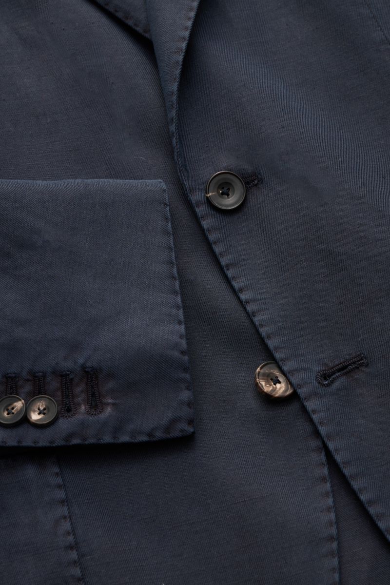 Close-up front view of Santaniello Smart-casual jacket navy showing button, lapel, and cuff details in cotton, linen, mohair blend.

Modern tailoring for the transitional period: This smart-casual jacket by SANTANIELLO enhances numerous spring looks wi