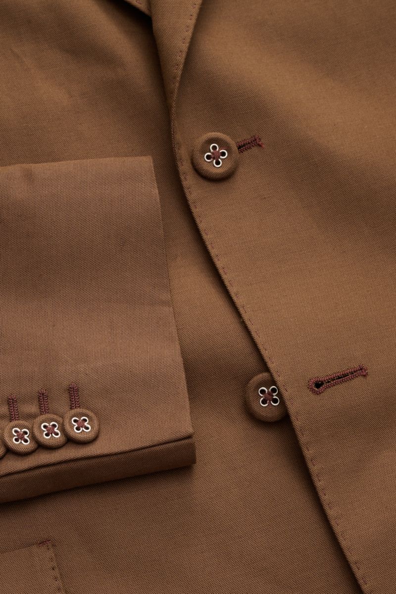 Close-up front-angle view of Officine Générale Smart-casual jacket 'Michel' brown, featuring lyocell, linen, cotton blend, buttons with floral detail, patch hip pockets, and neat stitching. Minimalist and elegant with smooth, lightweight fabric. 