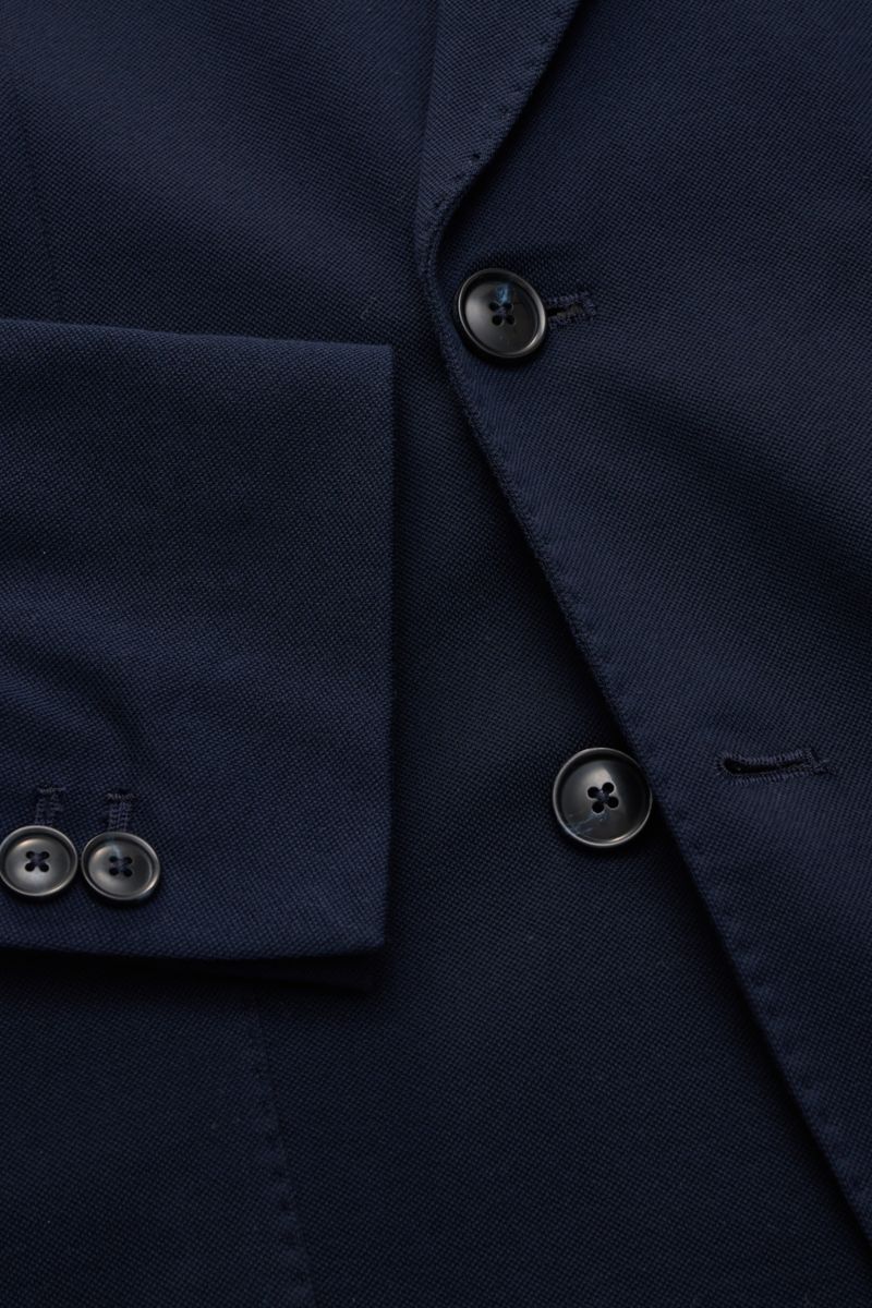 Nahaufnahme des Circolo 1901 Piqué Sakko navy aus elastischem Baumwoll-Piqué, schmal geschnitten im Slim Fit mit zweireihigem Drei-Knopf-Stil, Spitzrevers, klassischer Brusttasche, aufgesetzten Hüfttaschen und Ärmelabschlüssen mit Knöpfen, fotografiert vo