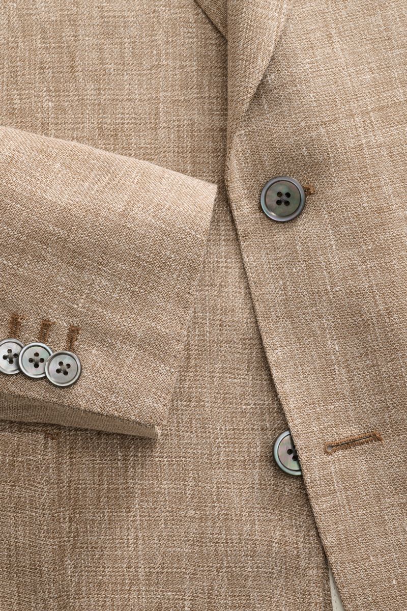 Close-up front view of Windsor Sakko 'Giorno' beige meliert jacket showing textured linen blend fabric, buttons, and lapel.

Leichtes Tailoring mit britischem Charakter: Das Sakko 'Giorno' von WINDSOR verbindet sommerliche Leinenqualität mit luxuriöser
