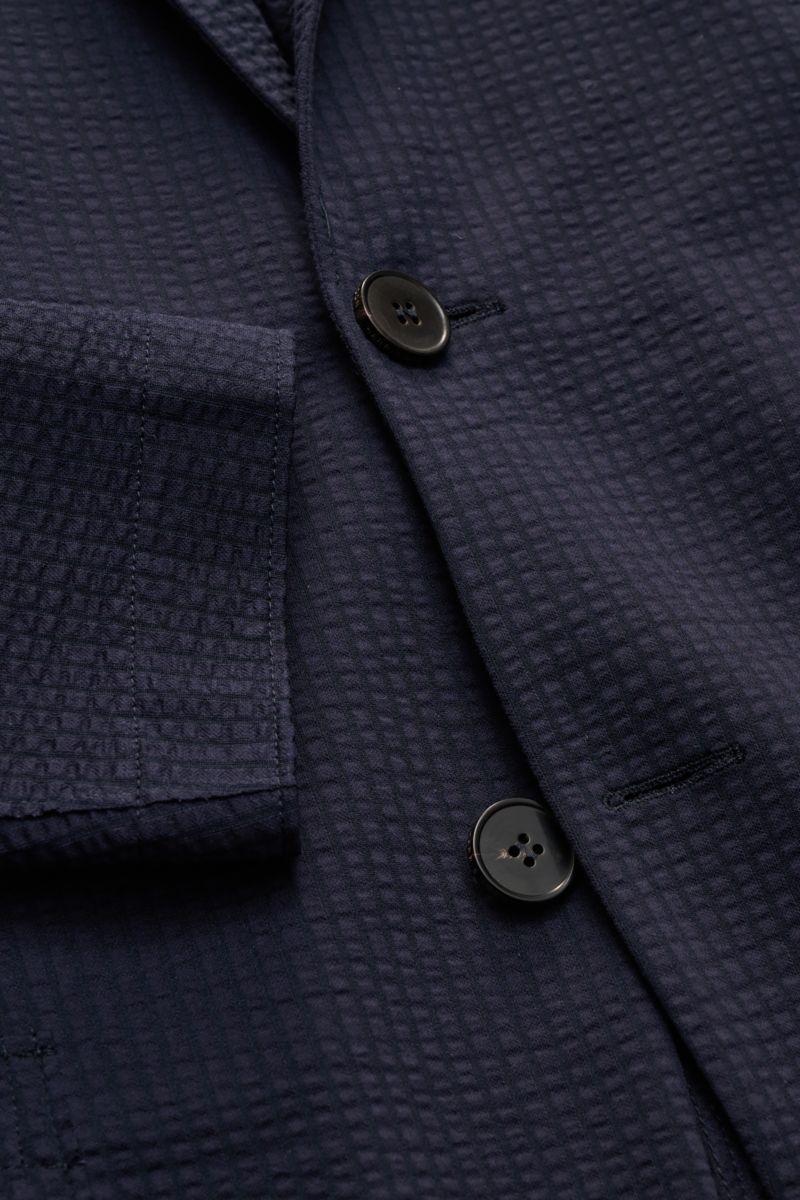 Close-up front view of Harris Wharf London Seersucker blazer navy showing textured cotton blend fabric, two-button front, patch pocket, and step lapel.

Style and unbeatable comfort: This sporty blazer in an unconstructed design by HARRIS WHARF LONDON 