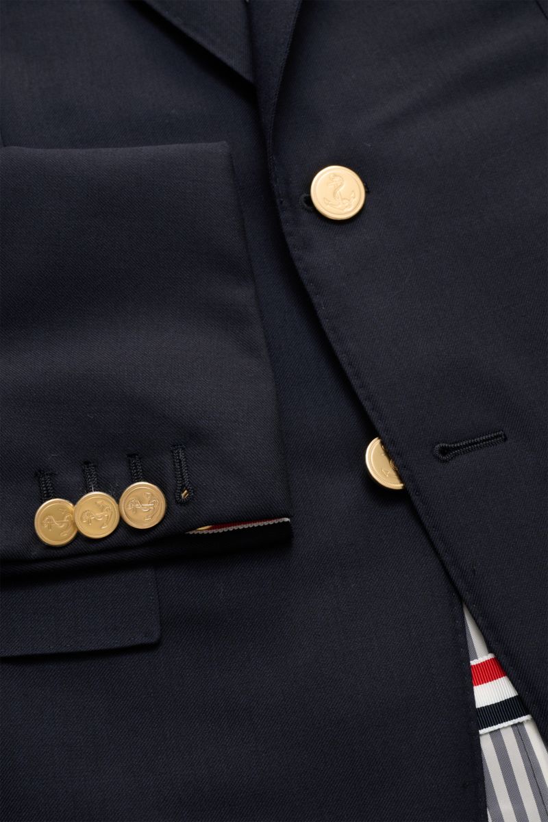 Nahaufnahme von Thom Browne Sakko navy aus reiner Wolle mit goldfarbenen Kissing Buttons, fallendem Revers und Ripsband-Tricolore, Slim Fit.