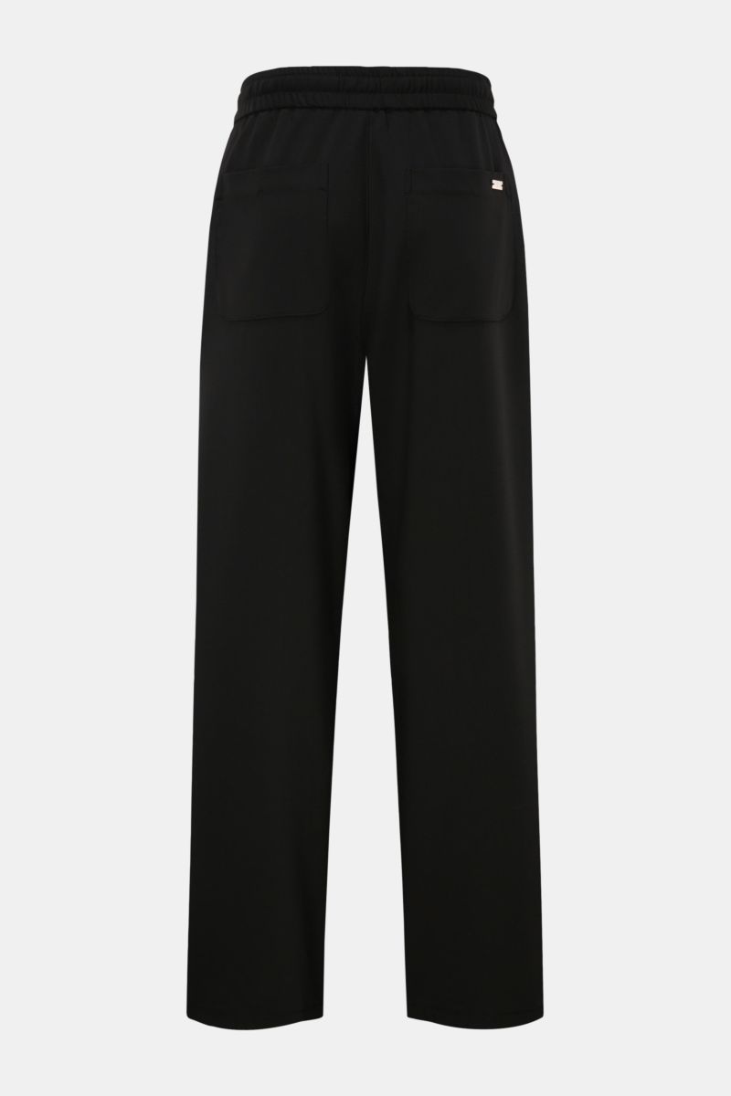 Ami Paris Jogger pants black shown from the back, featuring a high waist, elasticated waistband with drawstring, patch back pockets, and loose fit in pure virgin wool, lightweight fabric with a cool feel, zip and waist button, French pockets, and a slight
