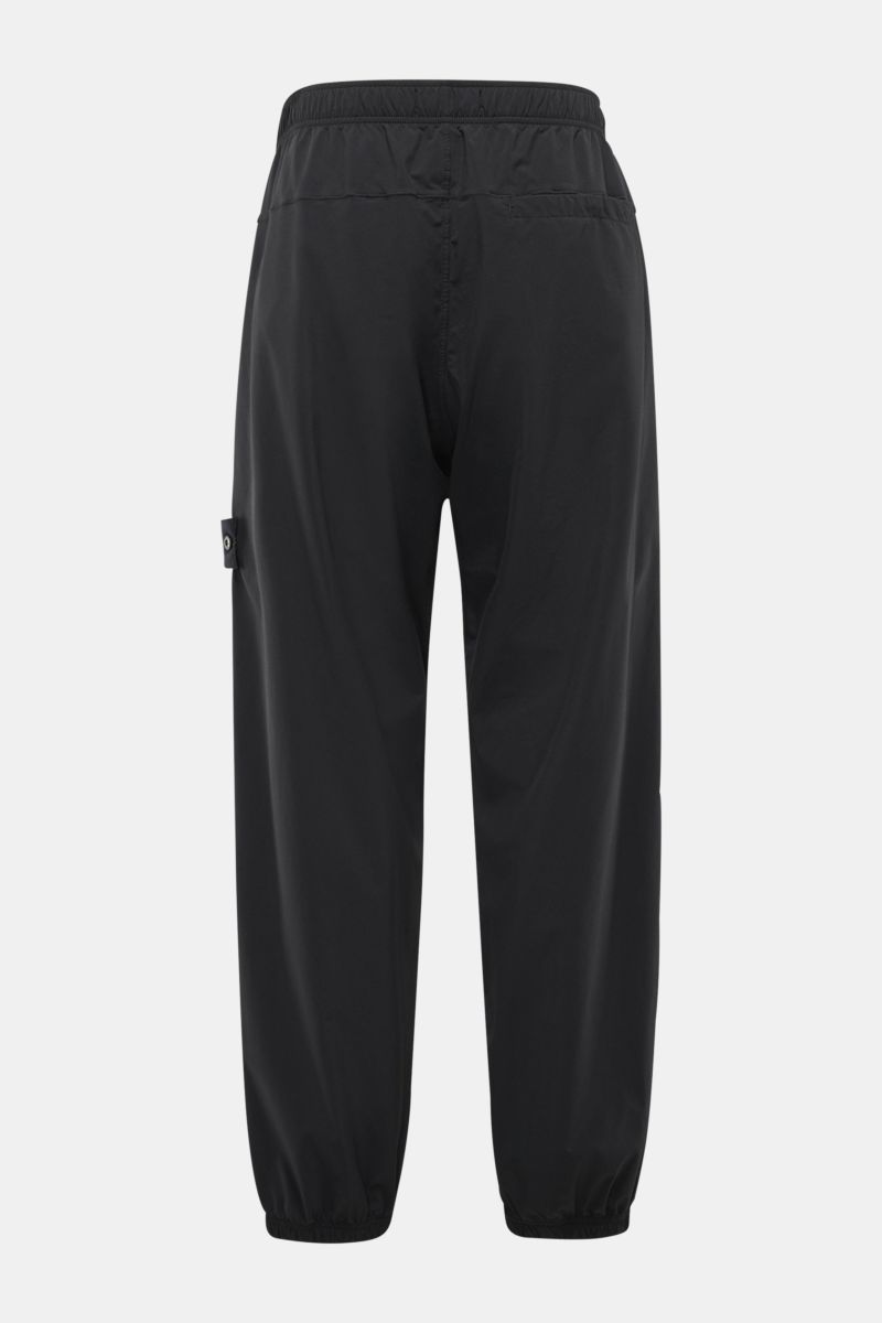 Rear view of Stone Island Jogger pants black in high-quality microfibre with a slightly robust touch, regular fit, elasticated waistband, zip pockets, and elasticated cuffs, designed for sporty and relaxed casual spring looks.