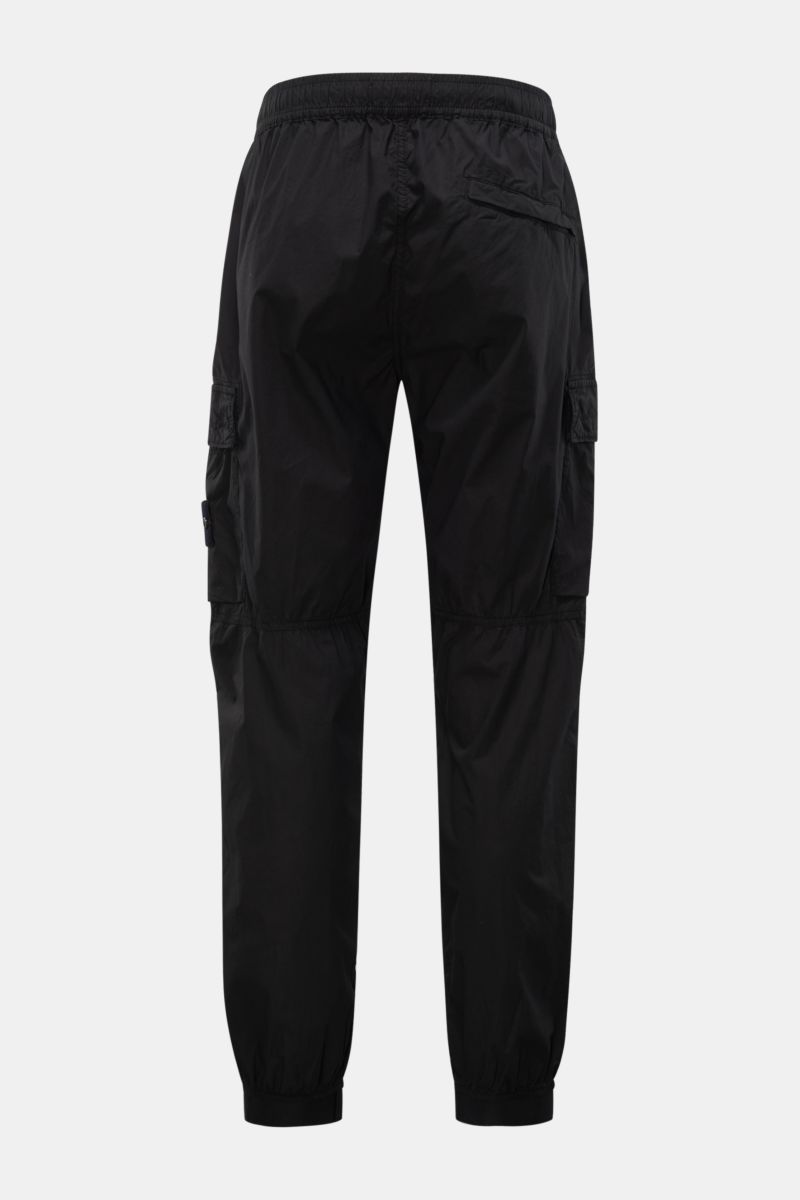 Black Stone Island Cargo-Jogpants 'Regular Tapered' schwarz shown from the back, made of elastic cotton with stretch, featuring soft touch, elastic waistband with internal drawstring, zippered pockets, side seam and classic cargo pockets, knee darts, back