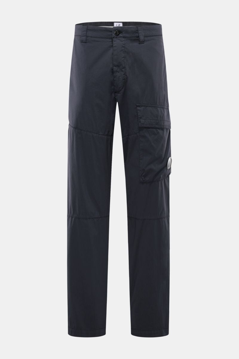 Front view of C.P. Company Cargo pants navy in a navy blend of cotton and microfiber, soft feel, tapered fit, straight cut, ankle length with zip, waist button, side seam and cargo pockets, jetted back pockets, and signature lens detail. Utility aesthetic