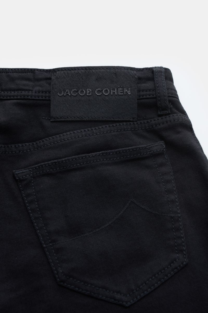 Close-up rear view of Jacob Cohen Jeans 'Bard' black (formerly J688) showing back pocket, signature pony skin patch, and belt loop. Denim made of cotton and microfibre, slight stretch content, lightweight robust fabric, slim fit, slightly tapered cut, but