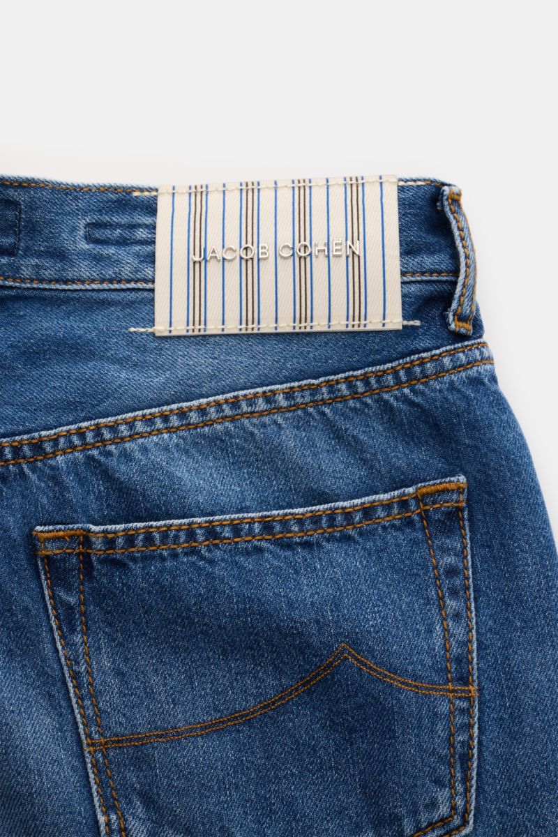 Close-up rear view of Jacob Cohen Jeans 'Edo' dunkelblau showing dark blue denim with subtle used wash, back pocket with stitching, and striped brand patch. Setzen Sie auf modernen Luxus im Alltag: Die Premium-Jeans 'Edo' von JACOB COHEN kombiniert haptis