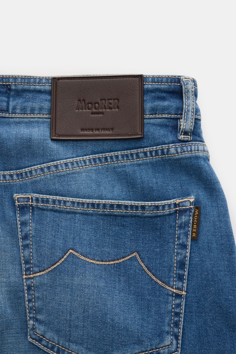 Close-up rear view of Moorer Jeans 'Milton' rauchblau showing denim pocket with stitching, leather patch, and logo tag, made in Italy. For casual denim looks: The 'Milton' jeans by MOORER offer unmatched comfort with elastic cotton denim, soft touch, subt