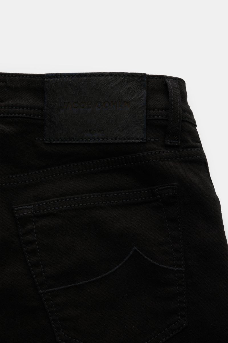 Close-up rear view of Jacob Cohen Jeans 'Bard' black showing back pocket with stitching, leather patch in pony skin look, five-pocket style, elasticated slim fit denim made of cotton and microfibre with soft feel, tapered cut, button fly, and coin pocket 