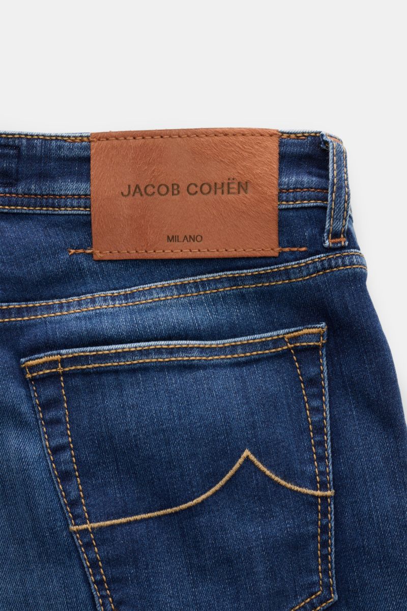 Jacob Cohen Jeans 'Bard' blau shown from the back waist, featuring soft elastic cotton denim with subtle used wash, slim fit, signature stitching, and a distinctive ponyhair-look leather patch.