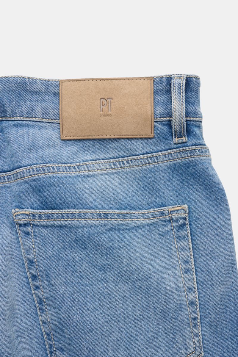 Close-up rear view of the PT Torino Denim Jeans 'Reggae' rauchblau showing the leather logo patch, denim cotton fabric with light stretch, slim fit, tapered, ankle-length, button fly, and five-pocket style. Das Cropped-Modell 'Reggae' aus dem italienis