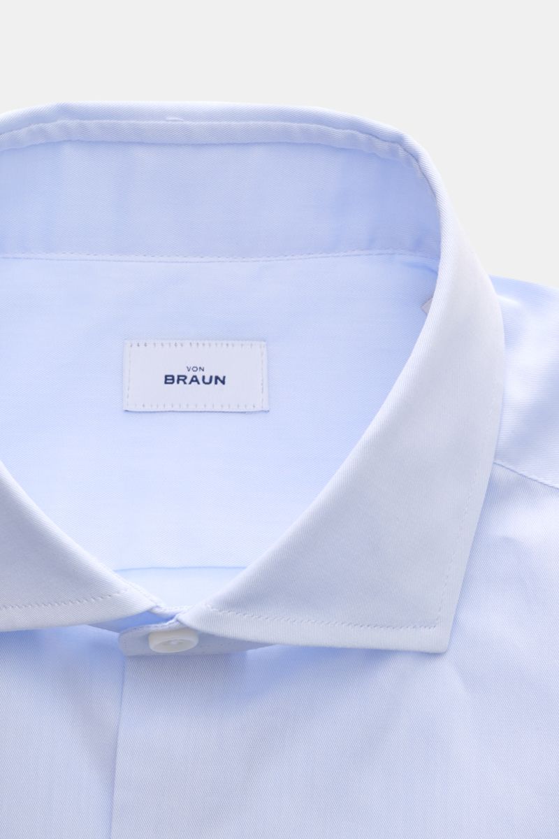 Close-up front view of the BRAUN Hamburg Business shirt shark collar light blue, showing fine cotton gabardine fabric, smooth feel, extra slim fit, shark collar, French button placket, classic barrel cuffs, waist darts at the back, and rounded hem.
