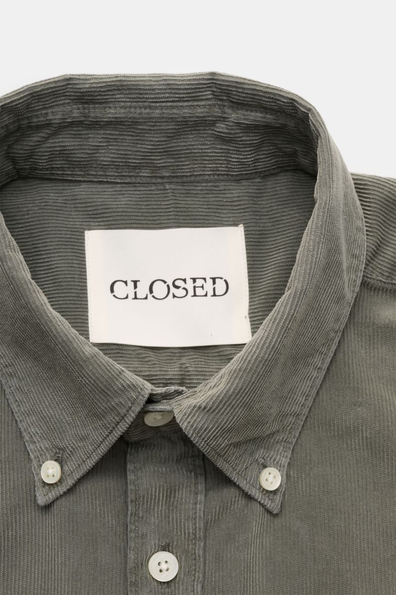 Close-up front view of the Closed Cordhemd Button-Down-Kragen graugrün shirt showing the button-down collar, pearl buttons, and fine corduroy texture.

Perfekt für den Herbst: Das stückgefärbte Feincord-Hemd von CLOSED verbindet warmen, soften Cordstof