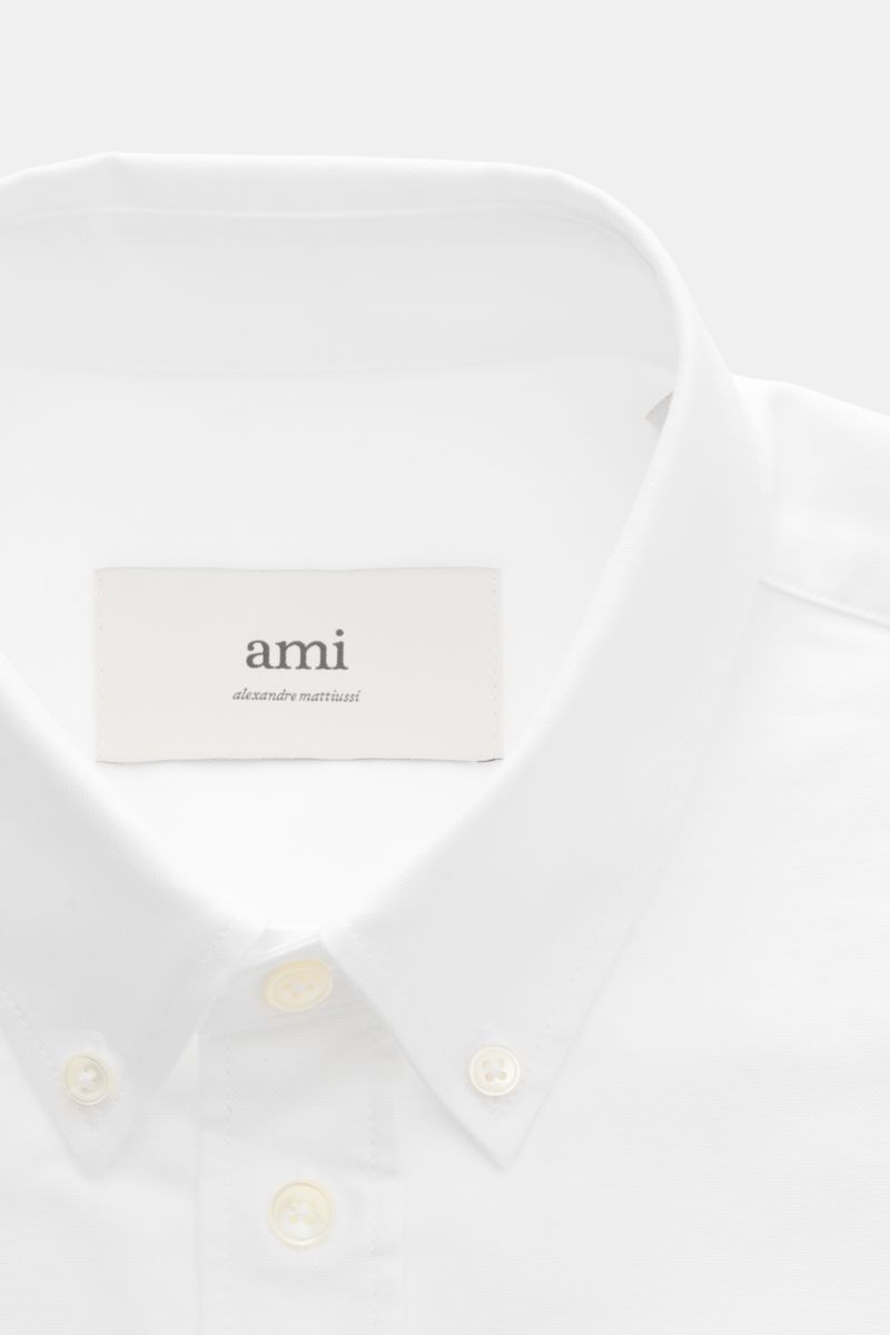 Ami Paris Oxford shirt button-down collar white shown from a close-up front perspective, highlighting the button-down collar, mother-of-pearl buttons, and signature heart stitching. For relaxed casual styles and more formal looks: This elegant shirt from 