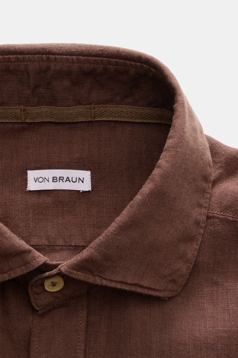 Nahaufnahme eines braunen von Braun Leinenhemd Haifisch-Kragen braun, perspektivisch von oben, zeigt reines Leinen mit weichem Griff und strukturierter Oberfläche.
