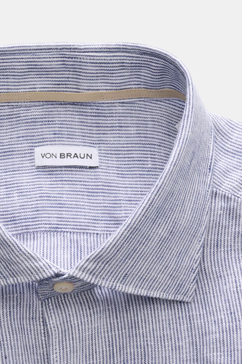Nahaufnahme von von Braun Leinenhemd Haifisch-Kragen navy/weiß gestreift, fotografiert von oben, reine Leinenqualität mit feinem Streifenmuster.