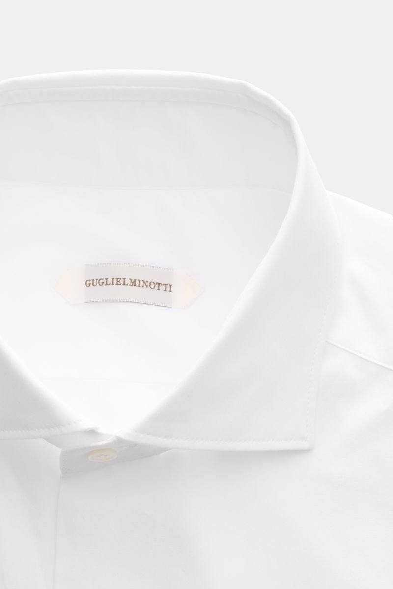 Close-up front view of Guglielminotti Casual shirt shark collar white in pure cotton, featuring a shark collar and smooth finish, French button placket with mother-of-pearl buttons, classic barrel cuffs, waist darts at the back, and a rounded hem. 