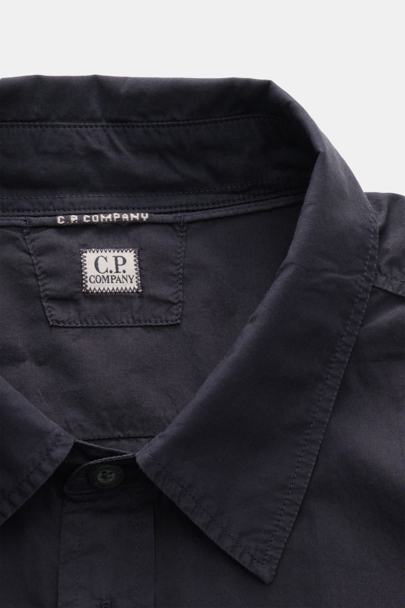 Nahaufnahme des C.P. Company Casual Hemd schmaler Kragen navy, fotografiert von oben auf den Kragen und das Logo aus reiner Baumwolle.