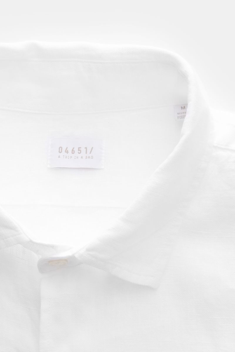 Close-up front view of the collar and label of the 04651/ A trip in a bag Leinenhemd schmaler Kragen weiß, a white linen shirt with a narrow collar, made of pure linen featuring lightweight, airy texture, French button placket, classic sport cuffs, rounde